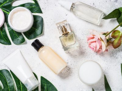 Skin care product, natural cosmetic, cream, tonic, lotion with green leaves. Flat lay image on white with tropical leaves.